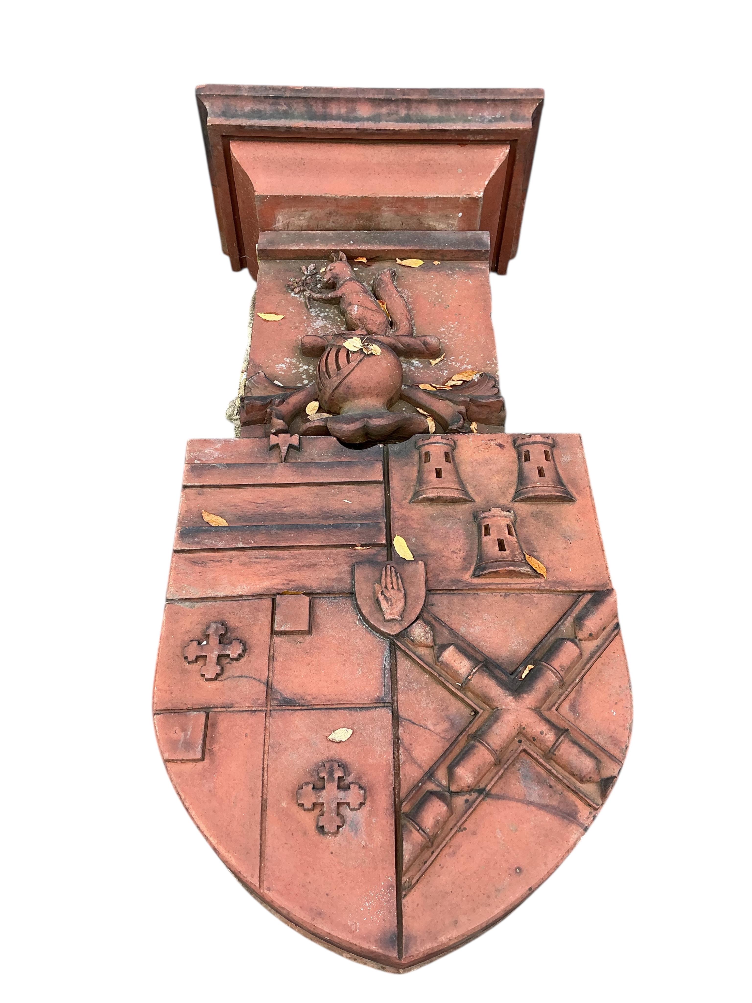 A Victorian terracotta country house armorial plaque, height 150cm with serpentine scroll corbels